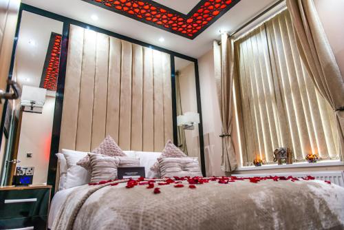 a bedroom with a bed with red roses on it at Aphrodite Suites in Bradford