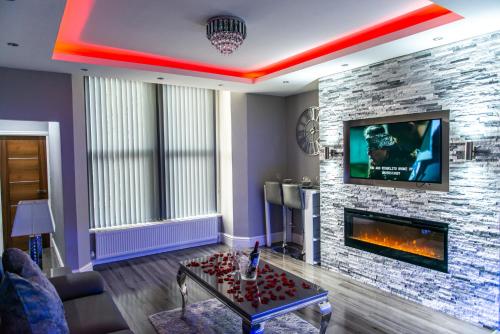 a living room with a fireplace and a tv at Aphrodite Suites in Bradford