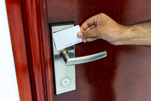 a hand unlocking a door with a piece of paper at Aphrodite Suites in Bradford