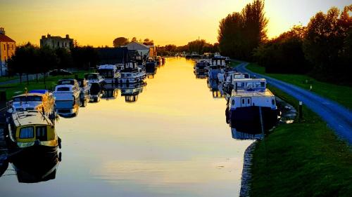 a group of boats docked in a canal at sunset at The Harbour Masters House in Banagher