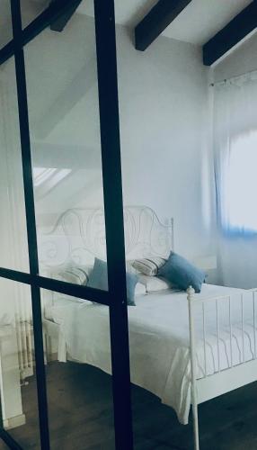 a bedroom with a white bed and a window at Castel Apartment in Castellamonte