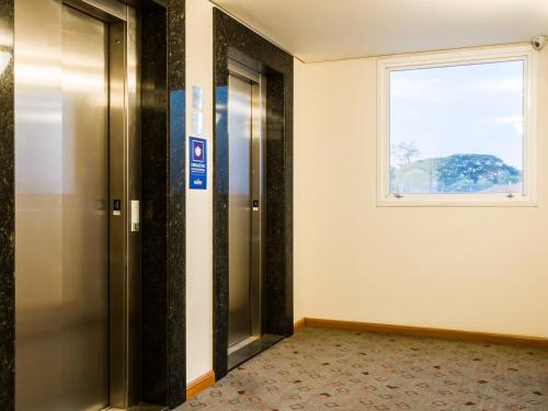 an elevator in a room with a window at ibis Jaboticabal in Jaboticabal