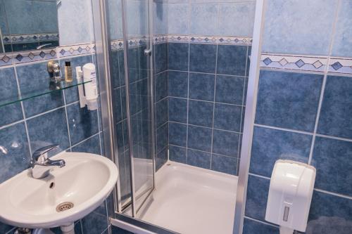 a bathroom with a sink and a shower at Hotel Amicus in Mostar