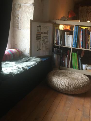 une chambre avec un lit et une étagère avec des livres dans l'établissement Le 395 charmant gîte proche Futuroscope, à Dissay