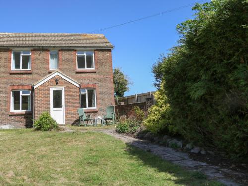 a brick house with a table and chairs in the yard at 1 Paythorne Farm Cottages in Henfield
