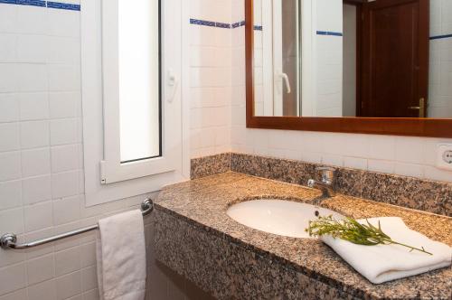 une salle de bain avec un lavabo et un miroir dans l'établissement Apartamento Ferrera Park 505, à Cala Ferrera