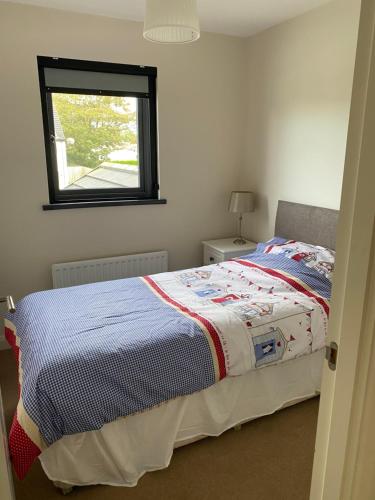 a bedroom with a bed with a colorful blanket on it at Westerlies in Portrush