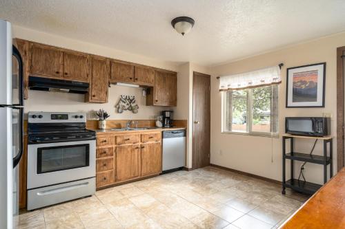 a kitchen with wooden cabinets and white appliances at Huckleberry House in West Yellowstone