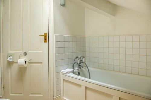een badkamer met een bad en een toilet bij Tyas Cottage in Slaithwaite