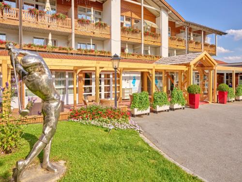 uma estátua na relva em frente a um edifício em Parkhotel Bad Griesbach em Bad Griesbach