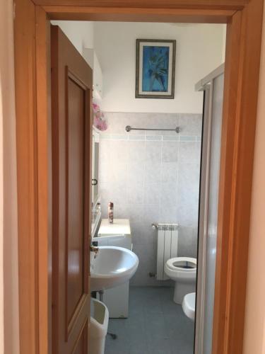een badkamer met een witte wastafel en een toilet bij House Turi in Ardea