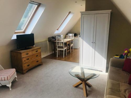 a living room with a couch and a table with a television at Rosebank B&B in Etchingham