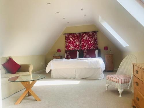 a bedroom with a bed and a chair and a table at Rosebank B&B in Etchingham