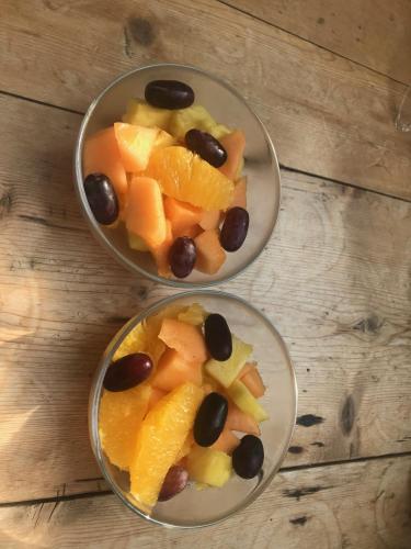 two bowls filled with fruit and vegetables on a wooden table at Rosebank B&B in Etchingham