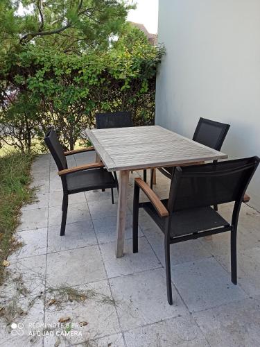 een houten tafel met 2 stoelen en een houten tafel en stoelen bij MON CABOURG PLAGE in Cabourg