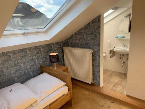 a bedroom with a bed and a sink and a window at Hotel Garni Maaß in Braubach