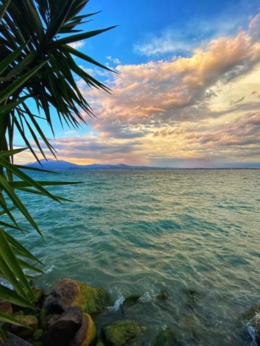 a view of the ocean with rocks in the water at Hotel Grifone in Sirmione