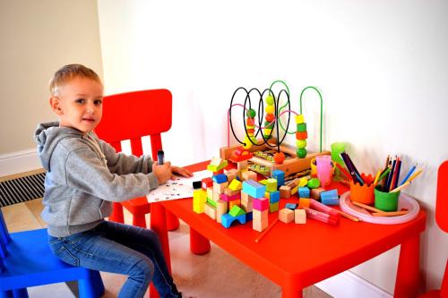 a young boy playing with blocks on a red table at Boutique Odyseja & Spa in Ciechocinek