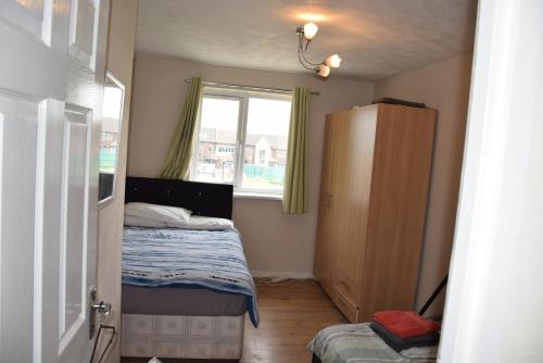 a small bedroom with a bed and a window at One Bedroom Flat, Granary Road in Ponders End