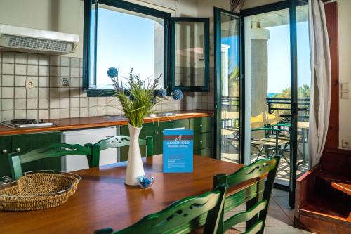 a kitchen with a table with a vase on it at Alkionides Seaside Hotel in Plataniás