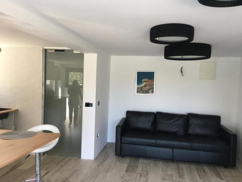 a living room with a black couch and a table at Trinity in Balatonalmádi
