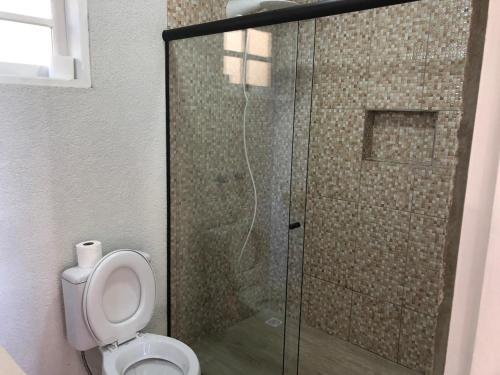 uma casa de banho com um WC e uma cabina de duche em vidro. em Villa Platô em Monte Verde