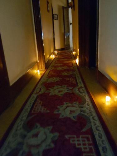 a hallway with a rug on the floor with lights at Cecilia Hostel in Cairo