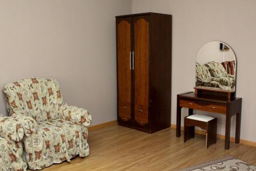 a living room with a chair and a dresser and a mirror at Golden Apricot in Gyumri