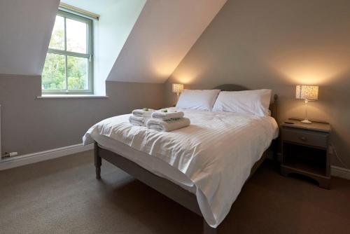 1 dormitorio con 1 cama con toallas en Dunvegan Castle The Farmhouse Cottage en Dunvegan