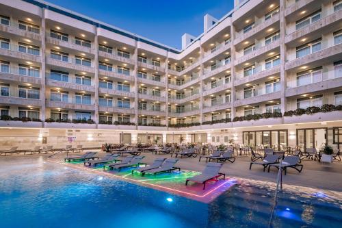 a hotel with a swimming pool in front of a building at Hotel Olympus Palace in Salou