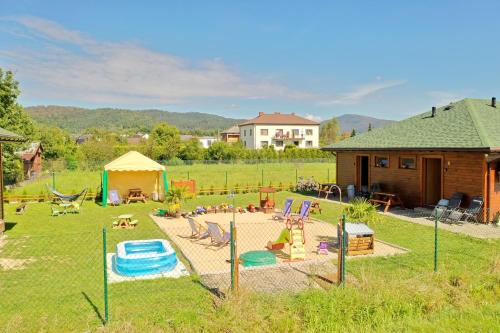 a playground in a yard with a house at Apartamenty przy Jeziorze Żywieckim z widokiem na Skrzyczne in Żywiec