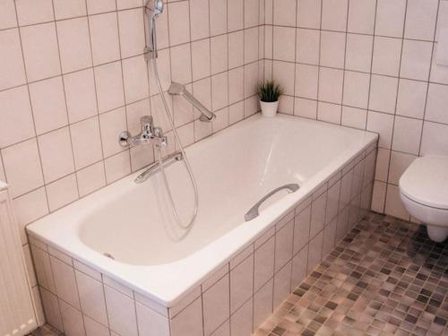a bath tub in a bathroom with a toilet at Ferienhaus Paula in Olsberg