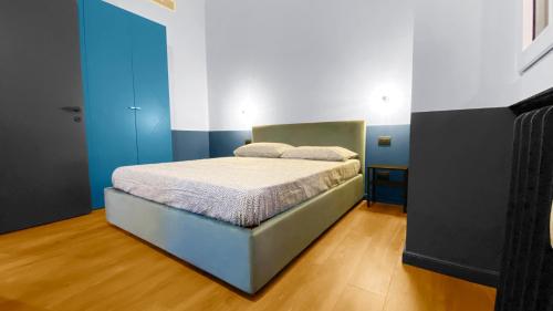 1 dormitorio con 1 cama con paredes azules y blancas en BNB Capital Milano Central Station - Red, en Milán