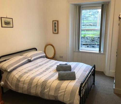 sypialnia z łóżkiem z dwoma ręcznikami w obiekcie Centrally located 2 bed modern flat with harbour views w mieście Wick