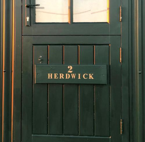 a green door with a sign on it at Barnham Court Farm in Barnham