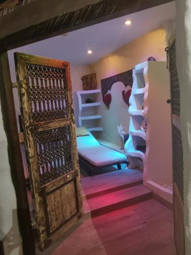 Cette chambre comprend un lit et une porte en bois. dans l'établissement La Grange-Piscine-SPA, à Fontenay