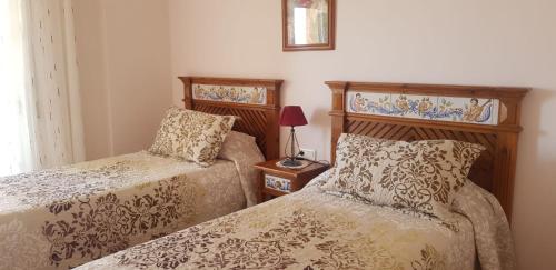 ネルハにあるAZAHARA 20のベッドルーム1室(ベッド2台、テーブルの上にランプ付)