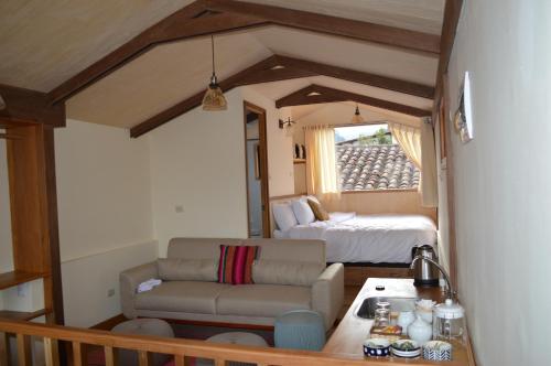 a living room with a couch and a bed at Nao Victoria Hostel in Cusco