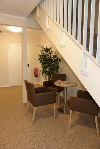 Habitación con mesa, sillas y escalera. en Ladiges Gasthof, en Holm