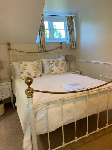 a bedroom with a large bed with white sheets and pillows at Kenilworth Guest House in Windermere
