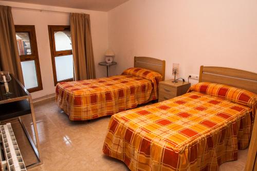 a hotel room with two beds in a room at Apartments Ca la Victoria in La Vilella Baixa