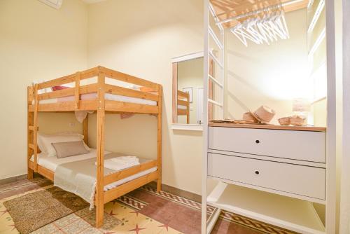 ein Schlafzimmer mit einem Etagenbett und einem Schrank in der Unterkunft Elevator's Beach House in Albufeira
