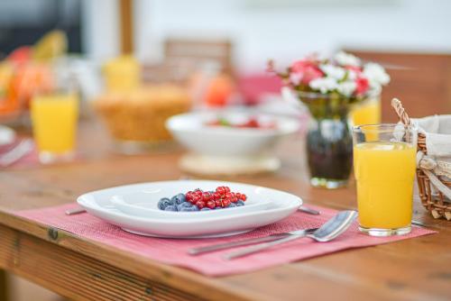 a plate of fruit on a table with orange juice at Elevator's Beach House by Atlantic Places in Albufeira