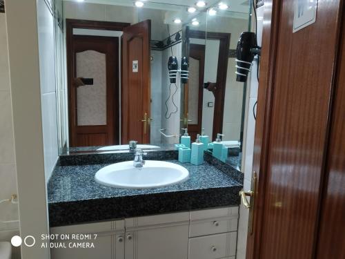 baño con lavabo y espejo grande en Casa Relax, en 