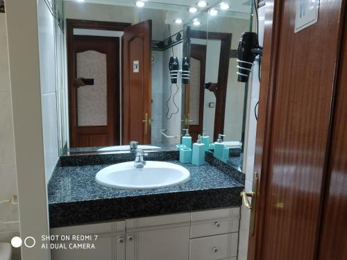 a bathroom with a sink and a large mirror at Casa Relax in Papiolet