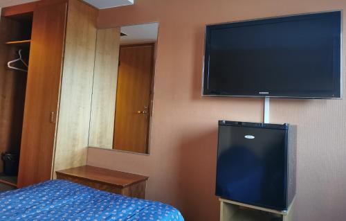 a bedroom with a television and a bed at Hotelli Iisoppi in Nokia