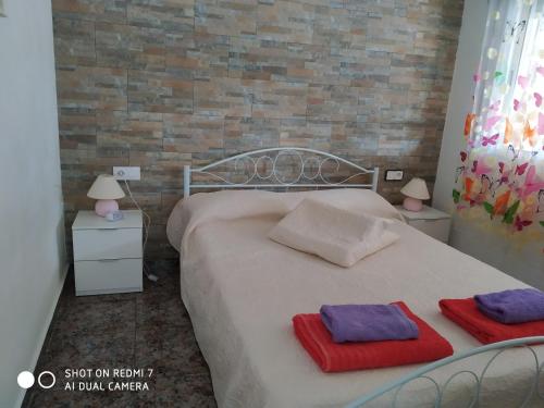 een slaapkamer met een wit bed en 2 handdoeken bij Casa Relax in Papiolet