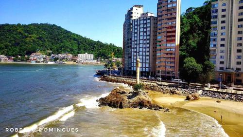 a view of a beach with buildings and the water at Família Pereira in São Vicente