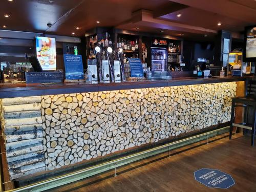 a bar with a stone wall and bottles of wine at Hotelli Iisoppi in Nokia