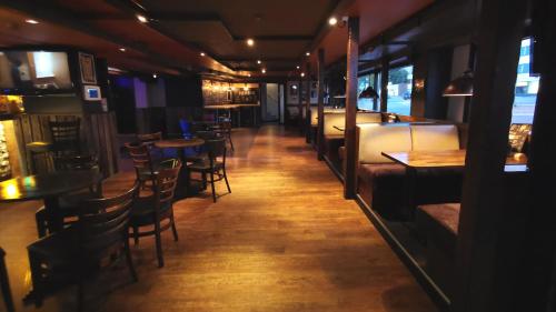 a bar with tables and chairs in a restaurant at Hotelli Iisoppi in Nokia